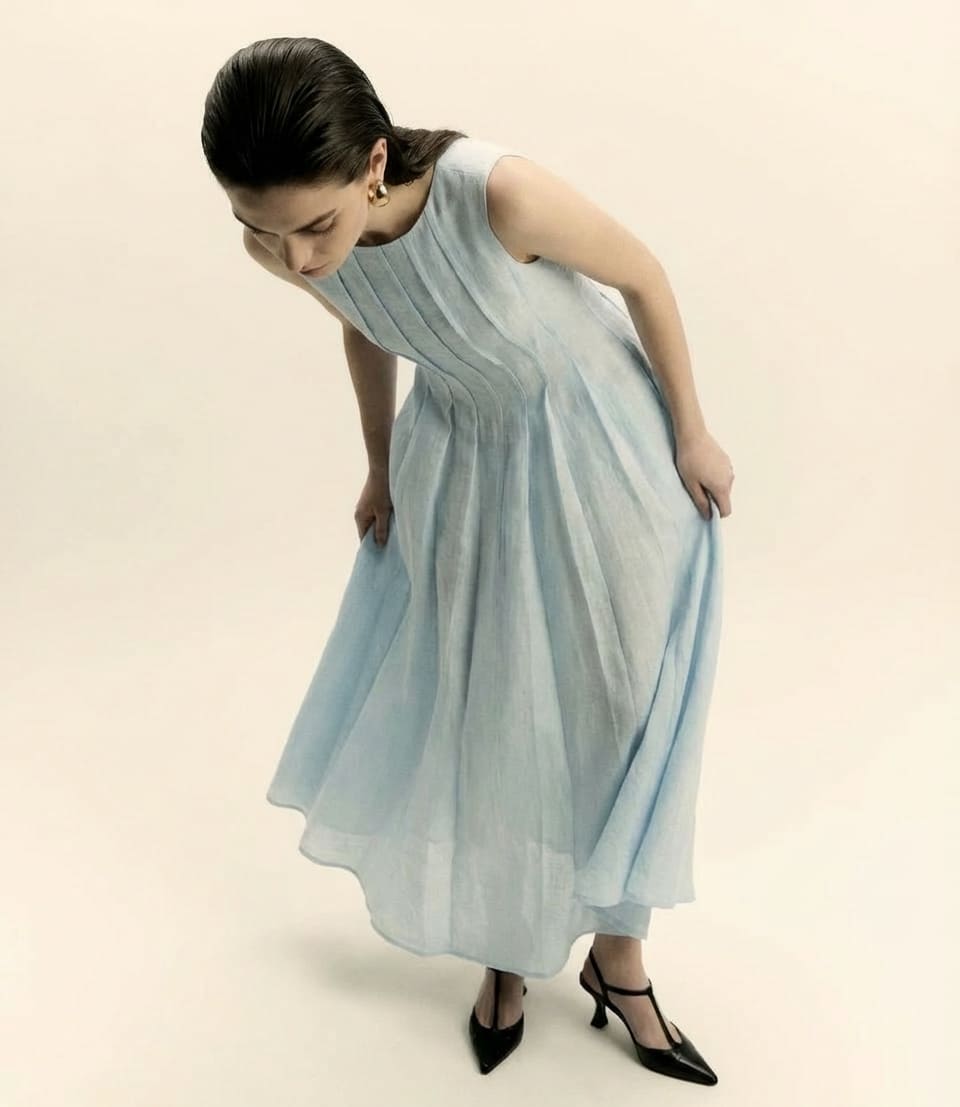 Woman wearing a light blue dress on a beige background