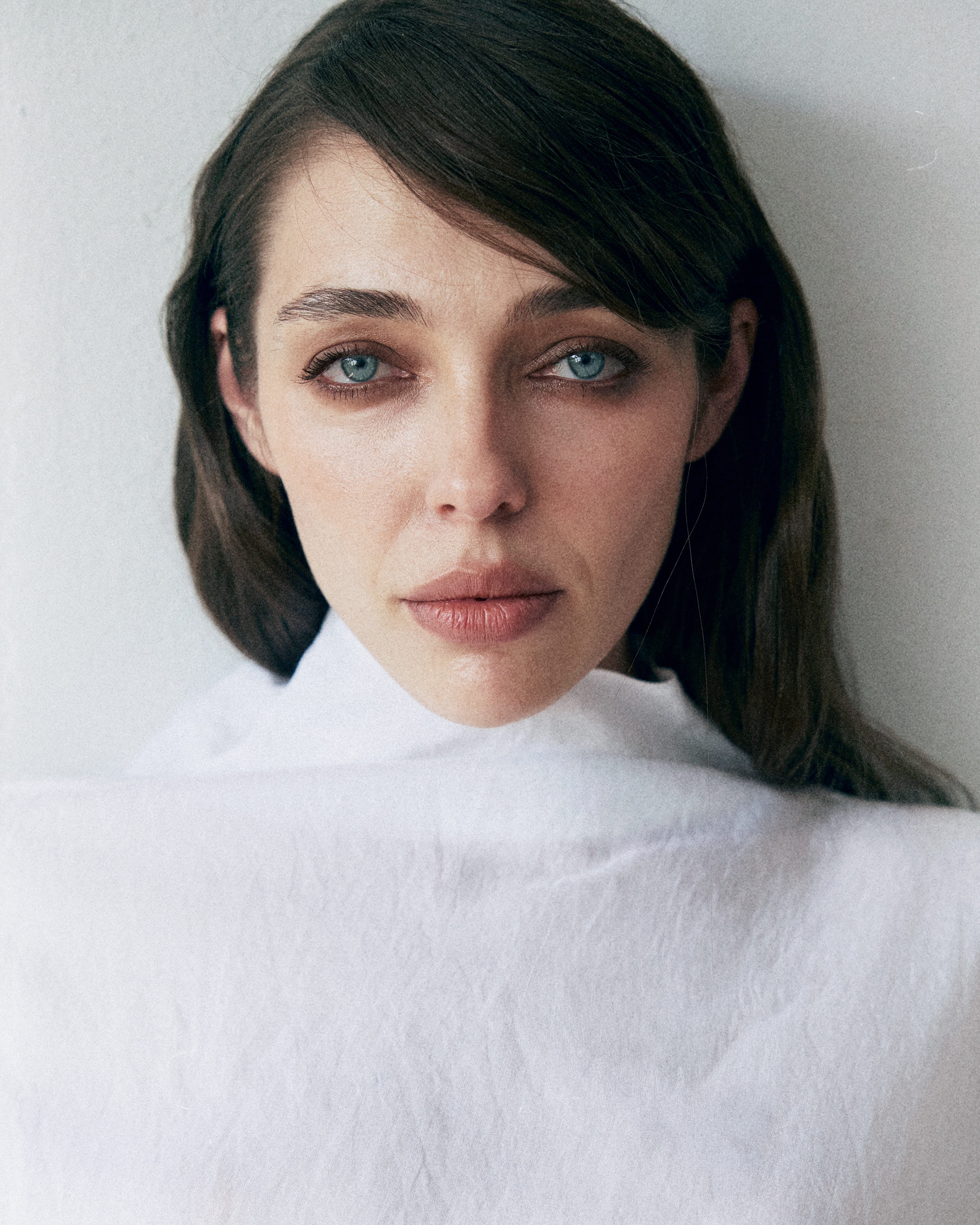 Woman wearing a white turtleneck against a plain background