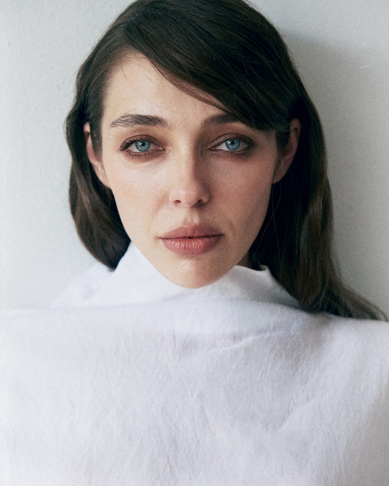 Woman wearing a white turtleneck against a plain background
