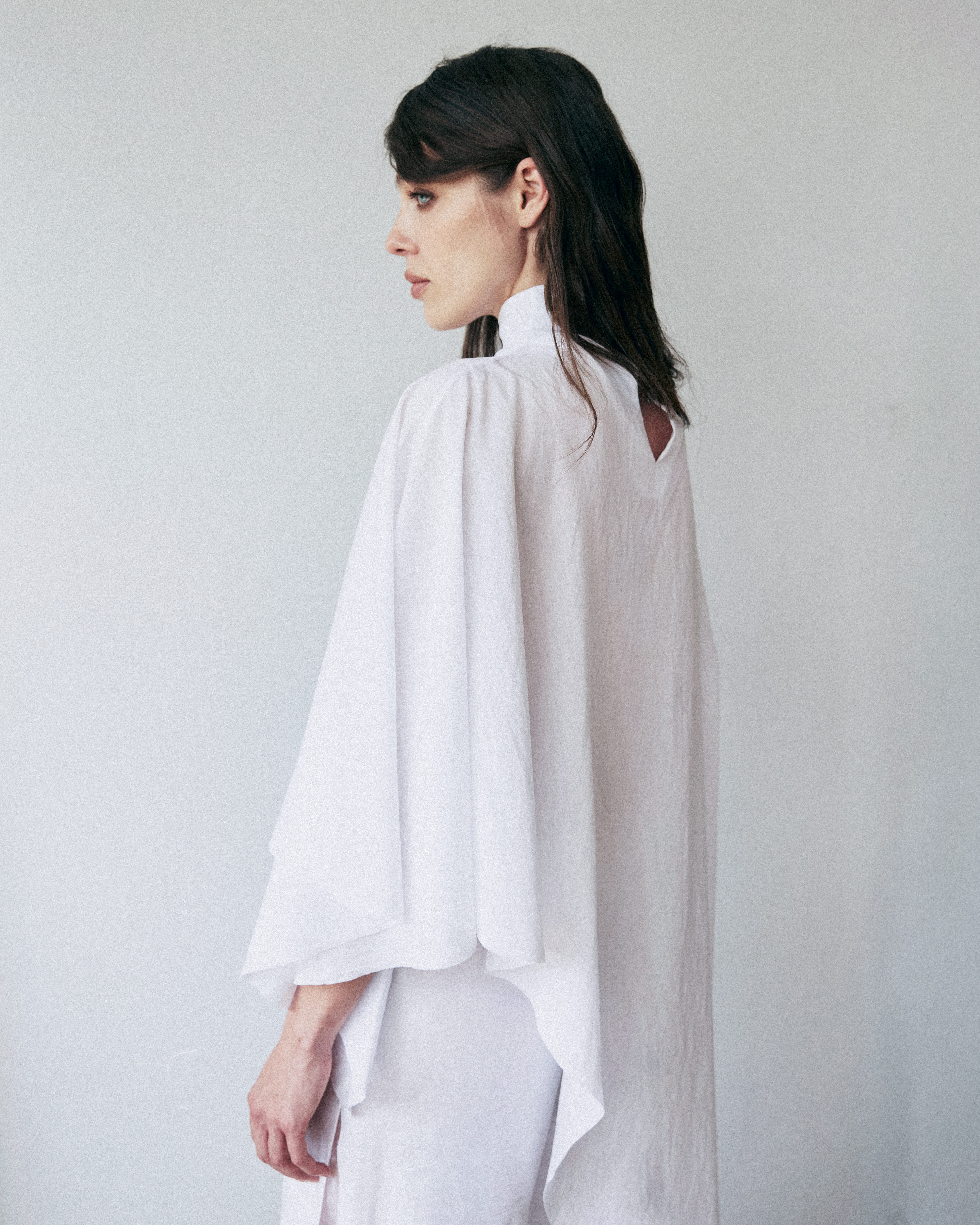 Woman wearing a white blouse against a plain background
