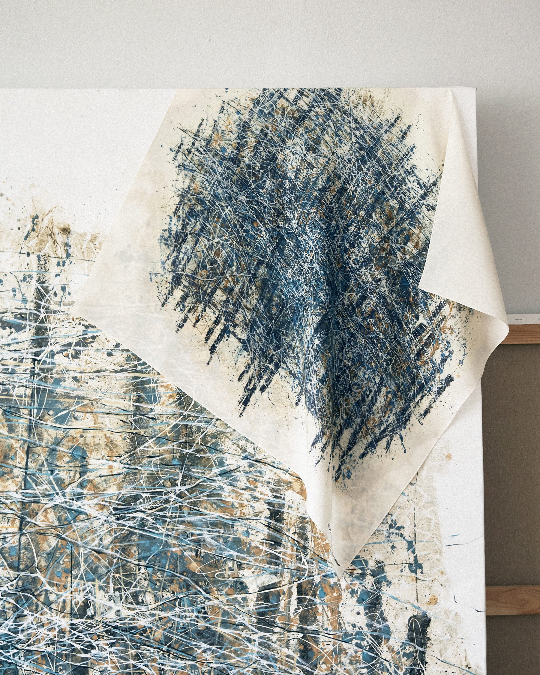 Abstract art piece with blue and white brush strokes on a light background