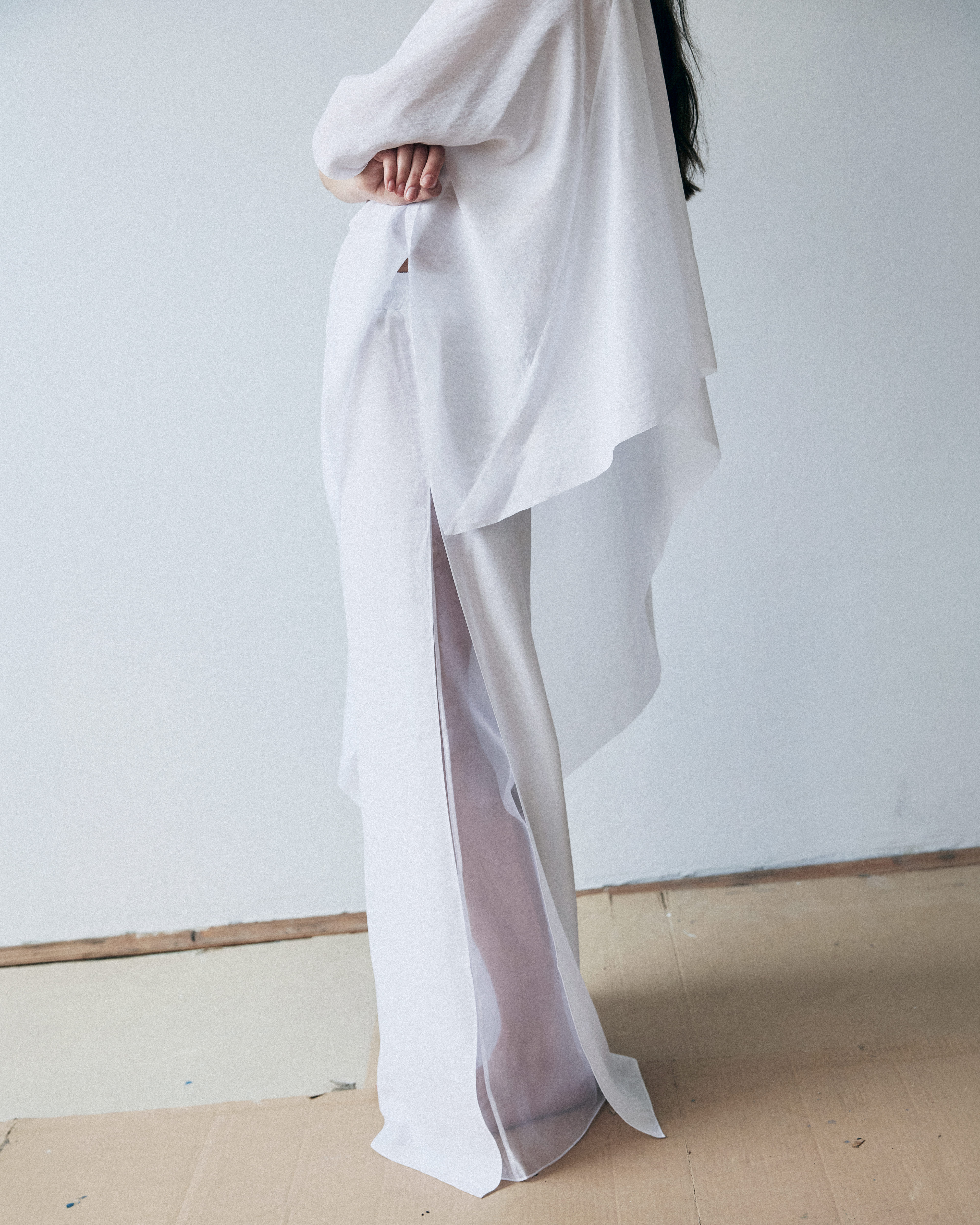 Person wearing a flowing white garment against a plain background